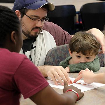 Two students work with a young boy as part of a Service Learning experience.